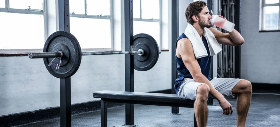 man drinking shake before bench press