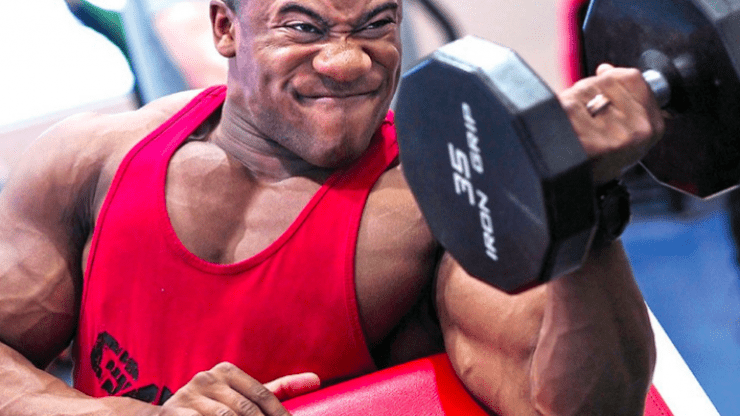 bodybuilder doing bicep curl with dumbell